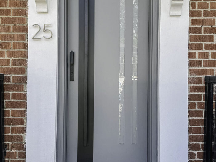 Modern smooth fiberglass front door with vertical glass and black accents