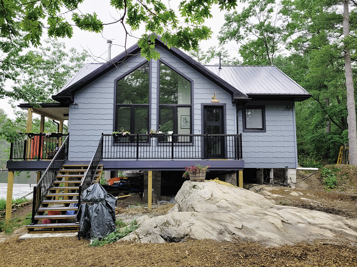 Exterior of Muskoka cottage with black vinyl casement and direct set windows following the roofline.