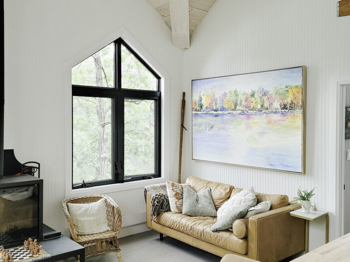Black vinyl casement and direct set windows following a vaulted ceiling inside a Muskoka cottage living
