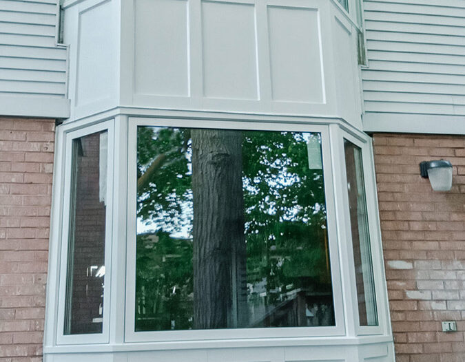 Stacked bay window with white box panel style skirts installed on a home in Pickering.