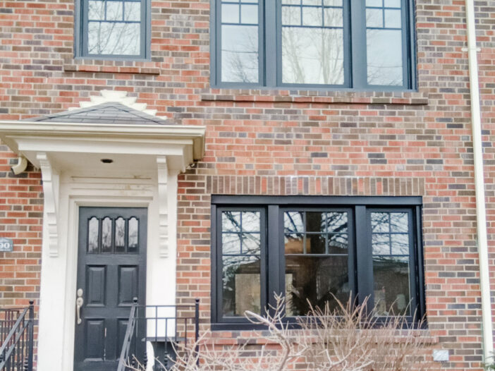 Black casement windows with SDL grilles installed on a two-storey Toronto brick home, replacing original white windows for a modern exterior update.