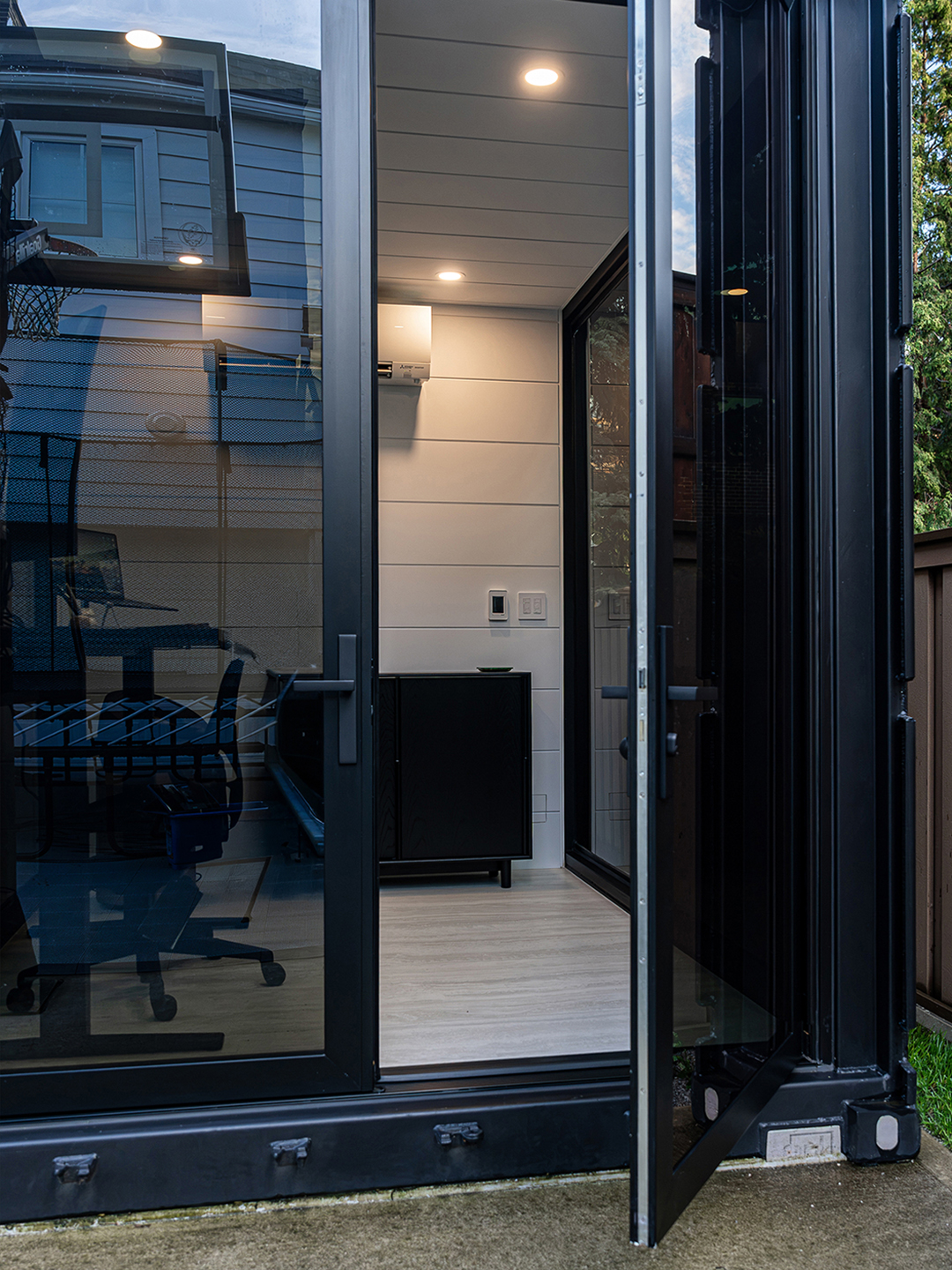 Open door view of the container office, revealing a seamless connection between the indoor workspace and the outdoor environment.