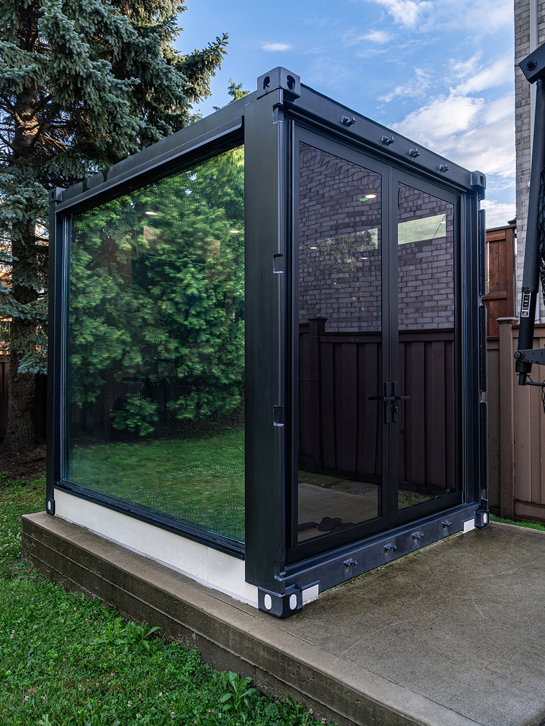 Side angle view of the container office highlighting the modern rail and stile door.