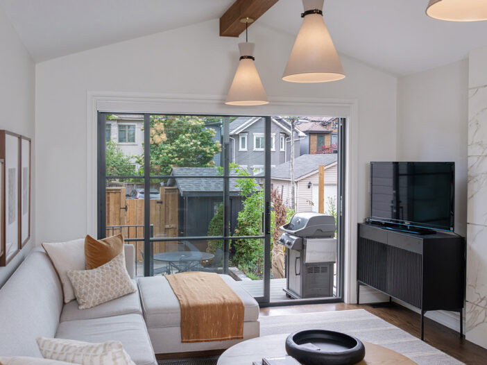 Custom sliding door in an Iron Ore finish with Colonial SDL grilles and black hardware, installed in a Toronto living room by Fieldstone Windows & Doors.