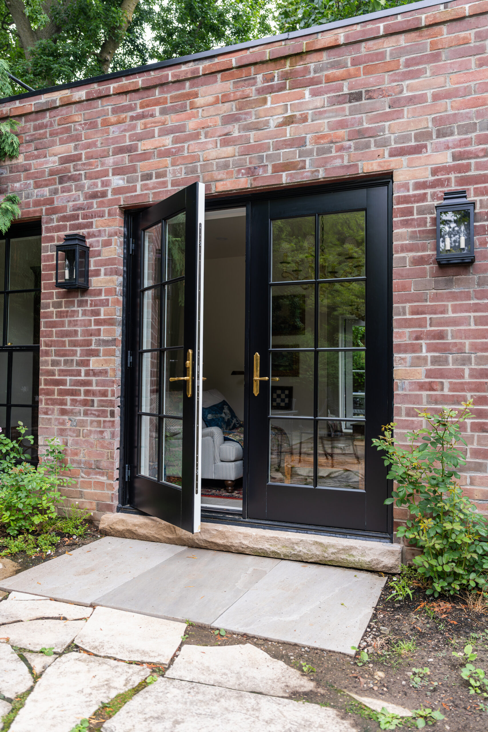Open wood French doors connecting Toronto garden studio to outdoor space.